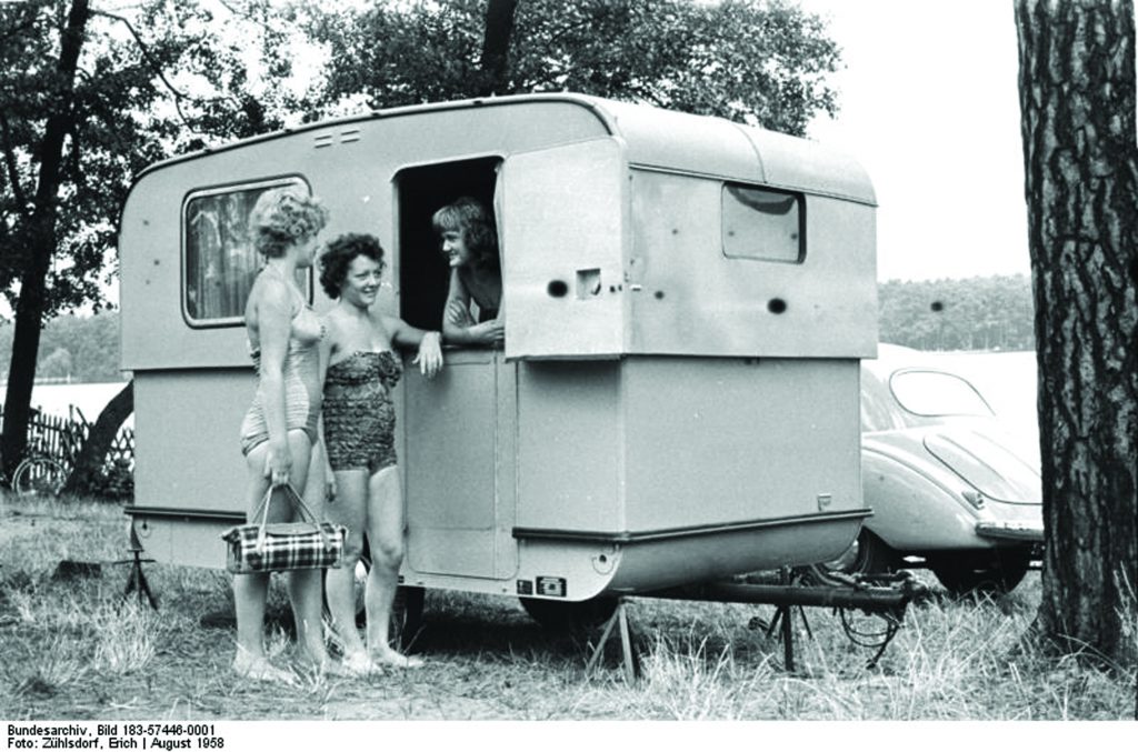 Zentralbild/Zühlsdorf 11.8.1958 Camping-Anhänger vom VES Spezialfahrzeugwerk Berlin-Adlershof Der doppelwendige isolierte Anhänger mit Schwungachse ist fahrbereit nur 158 cm hoch und kann daher mit 70 std/km transportiert werden. Am Ziel der Reise steht mit wenigen Handgriffen das "Heim auf Rädern" bezugsfertig da. Die Anrichte mit eingebautem, 2-flammigen Kocher hat genügend Raum für Geschirr und Wäsche. Der Anhänger ist ausgestattet mit federkern-gepolsterten Sitzen, die zur Nacht eine Liegestatt für 3 Personen ergeben. UBz: Aussenansicht des Camping-Anhängers.